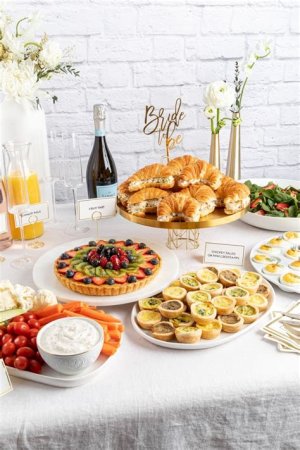 Brunch wedding buffet featuring pancakes, fresh fruit, eggs, and a coffee station set in a bright, morning-lit venue.