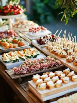Cocktail-style wedding reception with trays of mini sandwiches, skewered meats, and cheese platters, offering small bites for guests.