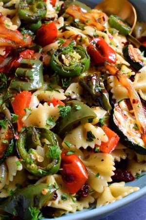 A wedding reception featuring pasta salad and grilled vegetables like zucchini, peppers, and asparagus served as a light, budget-friendly meal.