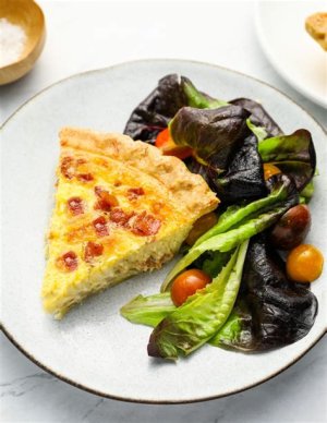 A wedding quiche buffet with a selection of quiches, including classic Lorraine, vegetable, and cheese varieties, served with salad or roasted vegetables.