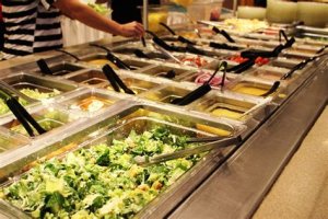 A soup and salad bar at a wedding reception with a selection of hearty soups, fresh greens, toppings, and dressings for guests to build their own salad.