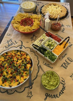 Taco bar at a wedding reception with tortillas, seasoned meats, fresh toppings like cheese, salsa, and guacamole, allowing guests to build their own tacos.